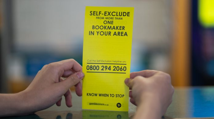 Person holding self-exclusion leaflet